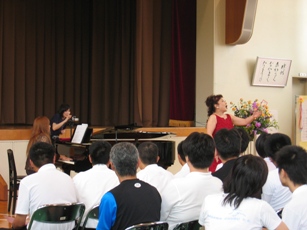 Mrs.Taemi Kohama is singing in front of students.jpg